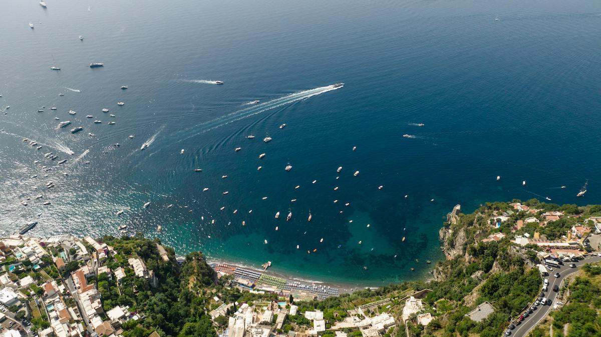 Amalfi Coast with clear water, green coastline and boats